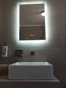 a bathroom with a white sink and a mirror at Τhe Diamond in Nea Peramos +31 photos