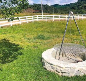 una vasca per uccelli nell'erba vicino a una recinzione di Casa Oliva com piscina e 6 quartos a Rancho Queimado