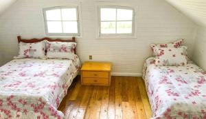 due letti in una stanza con due finestre di Casa Oliva com piscina e 6 quartos a Rancho Queimado