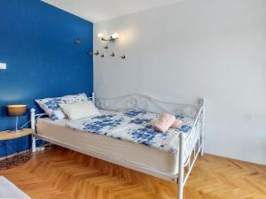 - un lit blanc dans une chambre dotée d'un mur bleu dans l'établissement Apartment Marija-2 by Interhome, à Omišalj