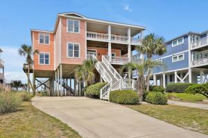 a large apartment building with palm trees and a staircase at West Point in Oak Island