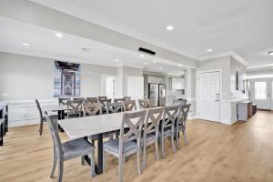 a dining room and kitchen with a table and chairs at West Point in Oak Island