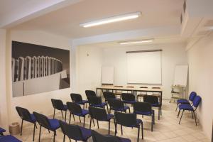 a classroom with blue chairs and a white board at Hôtel Les Rives Bleues in La Grande-Motte
