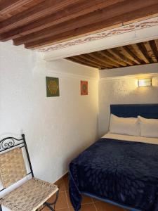 una camera da letto con un letto blu e una sedia di Riad Radia a Rabat