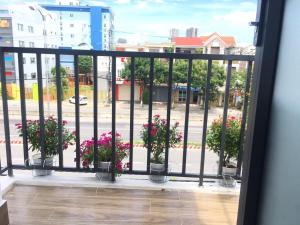 a balcony with potted flowers on a city street at CH Home in Danang