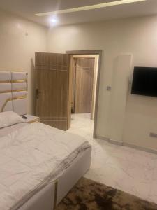 a bedroom with a bed and a tv on a wall at ADES Home in Lekki