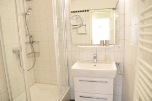 ein weißes Badezimmer mit Waschbecken und Dusche in der Unterkunft Kampstraße 9, W2, GB3 in Westerland + 19 Fotos