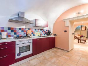 a kitchen with red cabinets and a stove top oven at Apartment Casa Derna by Interhome in Pietrabuona