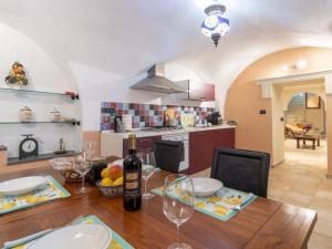 a kitchen and dining room with a table with wine glasses at Apartment Casa Derna by Interhome in Pietrabuona +20 photos