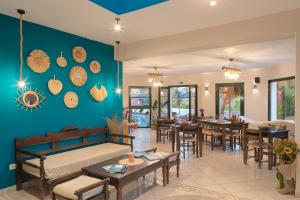 ein Wohnzimmer mit einem Bett, Tischen und Stühlen in der Unterkunft Nisea Hotel Samos in Pythagoreio