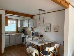 a kitchen with a table and chairs and a dog in it at ökologische Ferienanlage in Bansin