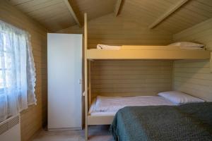 a bedroom with two bunk beds and a window at Efri-Vík Bungalows in Kirkjubæjarklaustur
