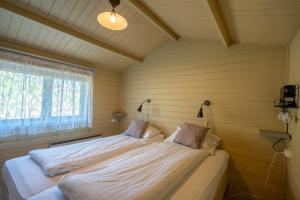 two beds in a room with a window at Efri-Vík Bungalows in Kirkjubæjarklaustur +109 photos