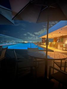a view of a swimming pool with an umbrella at Stella Maris Premium in Salvador
