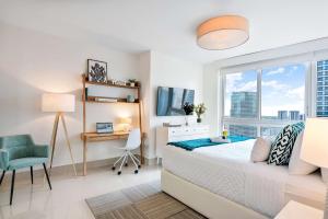 a bedroom with a bed and a desk and a window at MVR - Designer Condo in Prime Brickell in Miami +20 photos