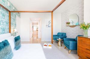 Una sala de estar con sillas azules y una cama. en MVR - Wake to Water & Skyline Views, en Miami