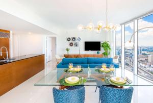 Una sala de estar con un sofá azul y una mesa de cristal. en MVR - Wake to Water & Skyline Views, en Miami 20 fotos más