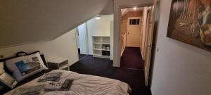 a bedroom with a bed and a hallway with a staircase at Ruime vakantievilla in Zeewolde in Zeewolde +27 photos