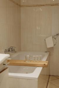 a bathroom with a bath tub with a wooden tray on it at Studio's De Vlijt Texel in De Cocksdorp +19 photos