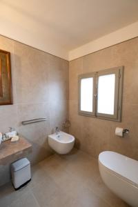 a bathroom with a tub and a sink and a toilet at Casa Diana Holiday Home in Montescudaio