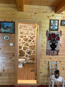a bathroom in a log cabin with a stone wall at Ranch below Ostrog in Gornja Povija +49 photos