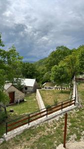 a wooden fence next to a field with trees at Ranch below Ostrog in Gornja Povija