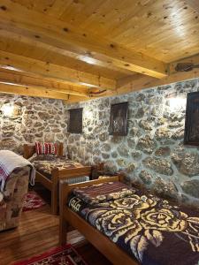 a room with two beds and a stone wall at Ranch below Ostrog in Gornja Povija