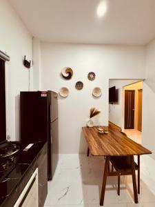 トンサラにあるSanguan Villa - Coconut Laneの木製のテーブルと冷蔵庫のあるキッチン