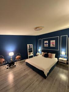 布加勒斯特Interbelic house with courtyard and terrace的一间卧室配有一张蓝色墙壁的床和两把椅子