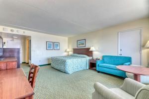 a hotel room with a bed and a blue chair at Blockade Runner in Myrtle Beach
