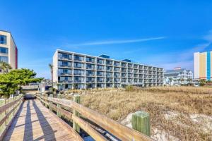 a hotel on the beach with a wooden boardwalk at Blockade Runner in Myrtle Beach