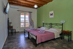 a bedroom with a bed with a pink blanket on it at Elysee Seaview Apartments in Sidari