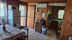 a small kitchen with a table and a refrigerator at Elefántos Kis Mókus Házikó in Zebegény