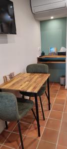 un tavolo in legno e 2 sedie in una stanza di La Bastide, Chambre d'hôtes a Castagniers