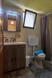 a bathroom with a toilet and a sink and a window at Elysee Seaview Apartments in Sidari