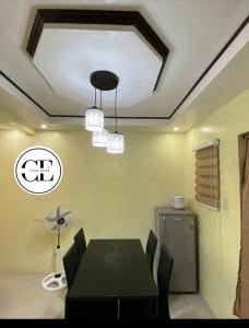 ein Esszimmer mit einem schwarzen Tisch und Stühlen in der Unterkunft Cathy's Transient House in Bacoor