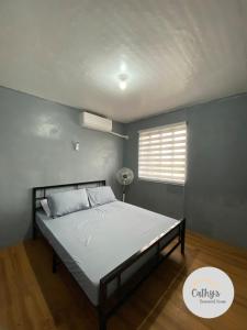 ein Schlafzimmer mit einem Bett in einem Zimmer mit Fenster in der Unterkunft Cathy's Transient House in Bacoor