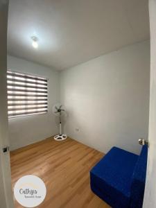 ein Wohnzimmer mit einem blauen Sofa und einem Fenster in der Unterkunft Cathy's Transient House in Bacoor + 2 Fotos