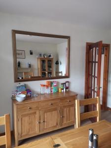 a large mirror on the wall above a wooden dresser at Gladstone Cottage in Inverness +9 photos