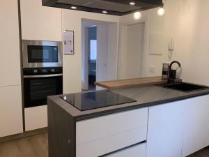 a kitchen with white cabinets and a counter top at Aldeia Bianca Cadimare in La Spezia