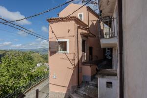 a pink building with stairs and a balcony at Casa Vacanze Da Angy & Gio in Grisolia