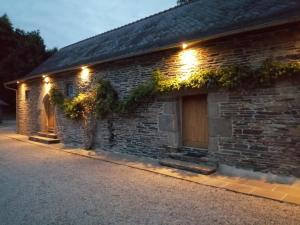 a brick house with lights on the side of it at La Longère du Manoir in Laniscat