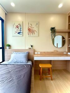Un dormitorio con una cama, un escritorio y un espejo. en 2BR Condo with Oldtown Bangkok Vibes, Steps from Wongwian Yai, en Bangkok