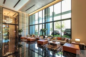 Un vestíbulo con sofás y mesas en un edificio. en 2BR Condo with Oldtown Bangkok Vibes, Steps from Wongwian Yai, en Bangkok