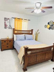 a bedroom with a wooden bed and a ceiling fan at Miami Casa in Miami Gardens +8 photos