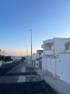 an empty street with white buildings on the side at Appart NUOVO Sorgenti Sup by Salento Prime in Marina di Pescoluse