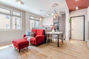 a living room with a red chair and a table at Nuovo appartamento con posto auto privato a 5 min a piedi dal centro in Siena