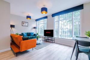 a living room with a couch and a table and a tv at Elysée Suites - Lovely 2 Bed Flat in Southport in Southport +51 photos