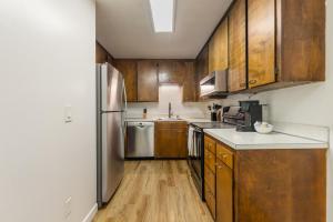a kitchen with wooden cabinets and a stainless steel refrigerator at Comfortable Townhouse in Ash Way Lynnwood in Lynnwood