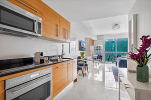 a kitchen with wooden cabinets and a counter top at MVR Sleek Condo with Iconic Views in Miami